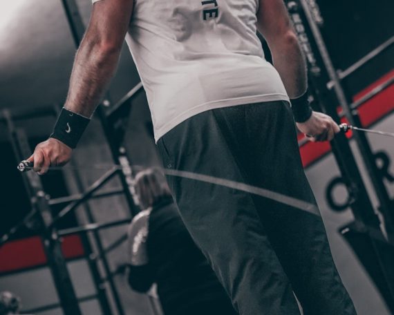 a man standing on a bar in a gym
