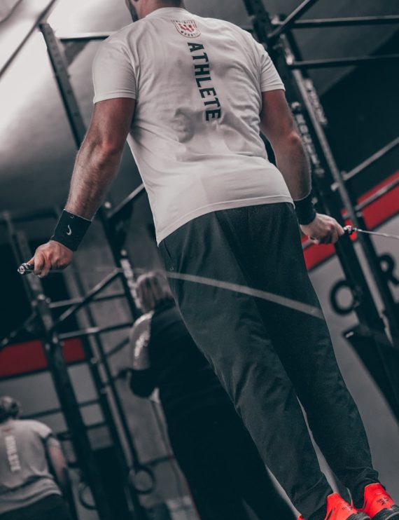 a man standing on a bar in a gym